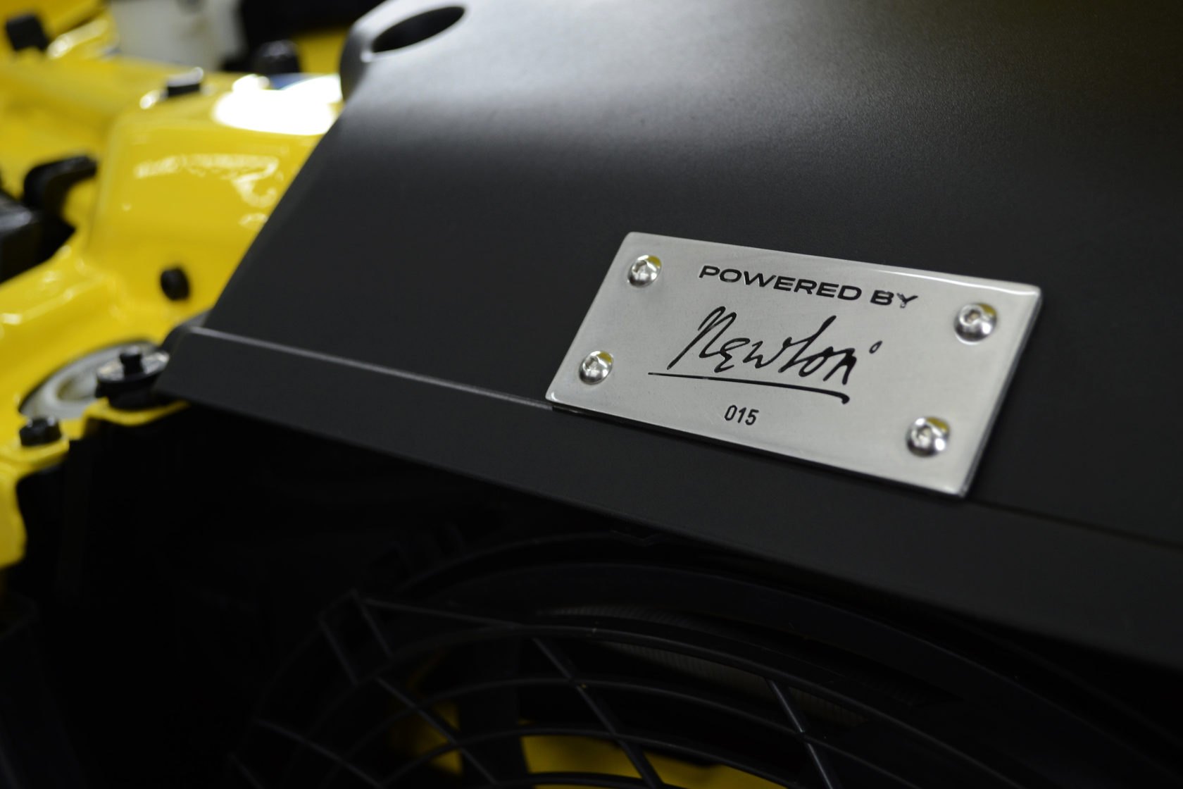 Та же табличка POWERED BY Newton с номером 015 крупнее, под ней решётка вентилятора