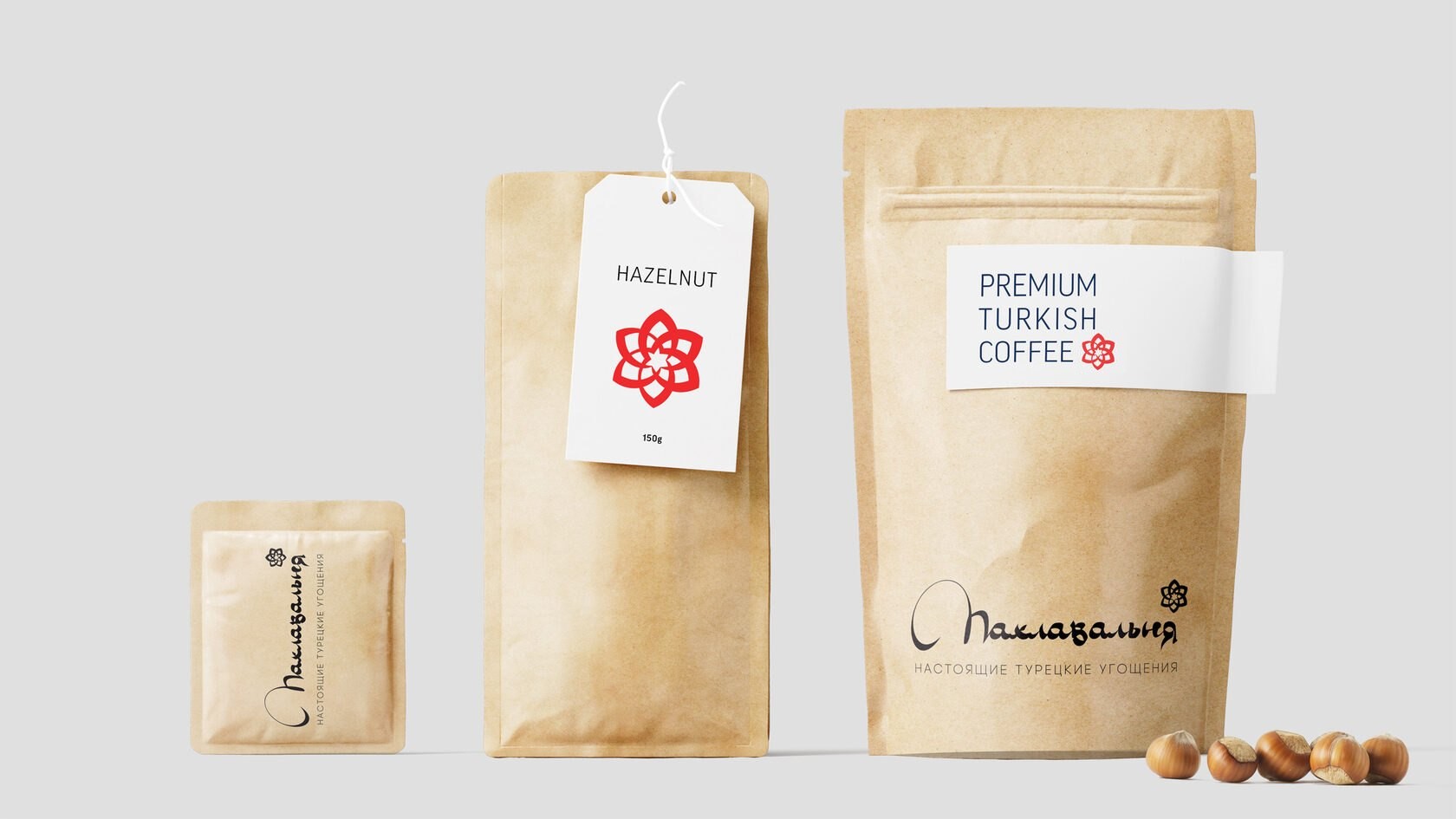 Крафтовая упаковка с логотипом «Пахлавальня»: саше, пакет с белой биркой HAZELNUT 150g и красным знаком, пакет с наклейкой PREMIUM TURKISH COFEE; рядом лесные орехи